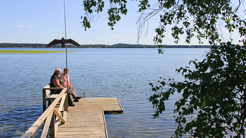 Kuvassa laituri kuoringalle päin, jossa istuu nainen ja mies